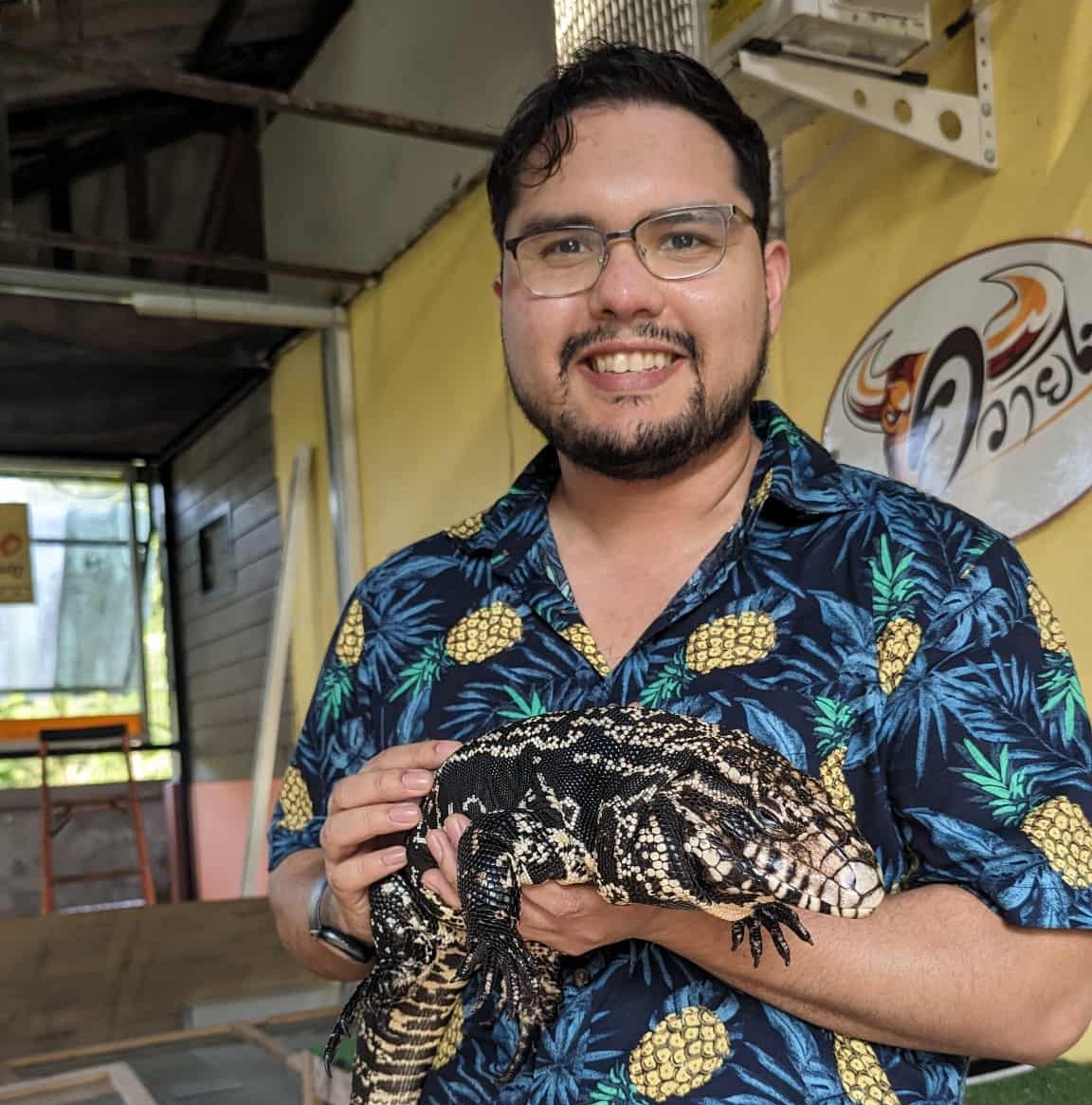 a photo of Carlos Raygoza holding a black and white Argentine Tegu